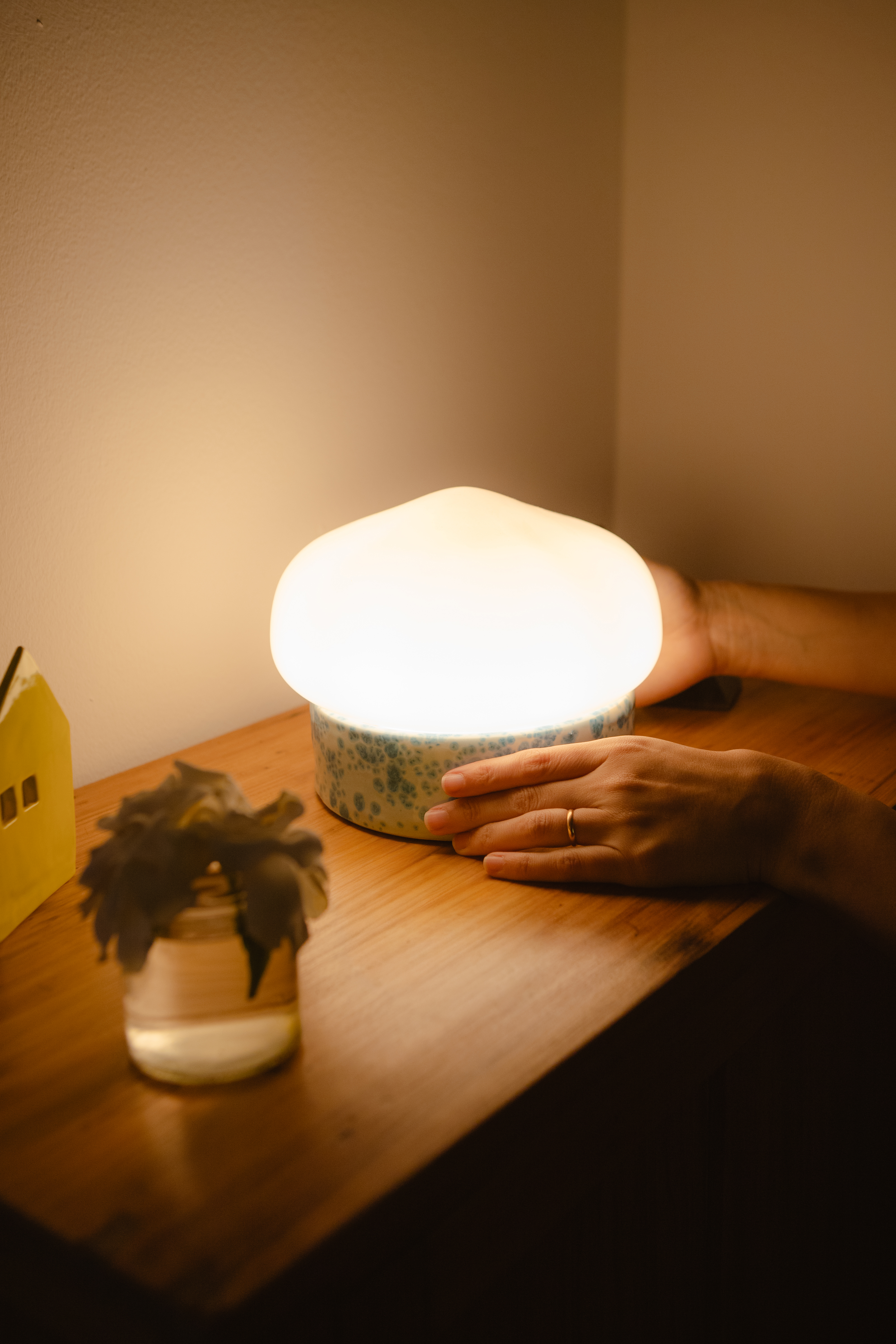 Una lámpara de Maruja encendida sobre una mesa de madera